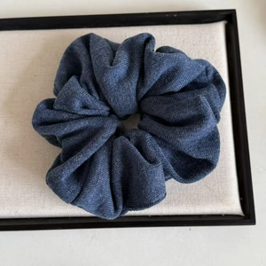 Solid navy blue knitted scrunchie with soft ribbed texture for messy bun hair styling