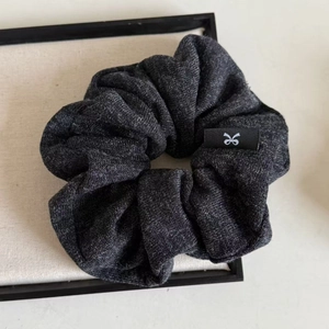 Knitted oversized hair scrunchie in dark grey with woven texture and a logo tag