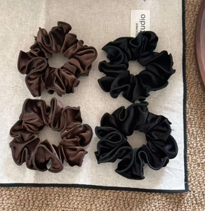 Detail of premium velvet hair scrunchies in coffee and black with high-density pleats