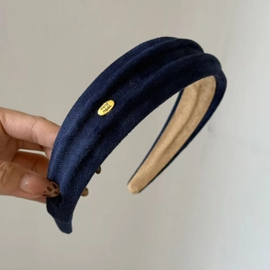 Detailansicht des dunkelblauen Wildleder-Haarreifens mit goldenem Hand Made Metall-Logo