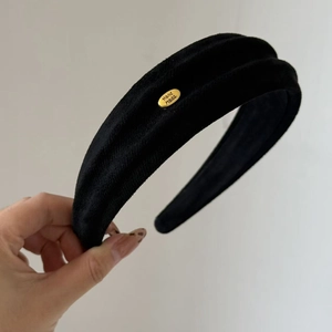 Detail von schwarzem Stirnband aus Wildlederimitat mit handgefertigtem Gold-Logo