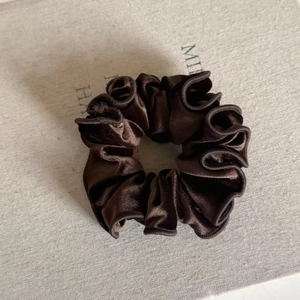 Detail of coffee velvet scrunchie showing fine stitching and smooth fabric texture