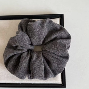 Detailed close-up of dark grey knitted hair scrunchie showing fine fabric texture