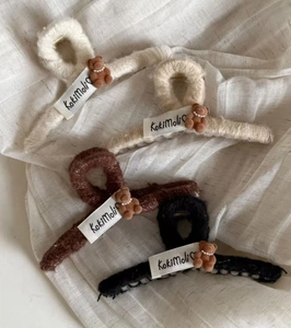 Detail of plush shark hair clips featuring cute teddy bears with pearl necklace accents