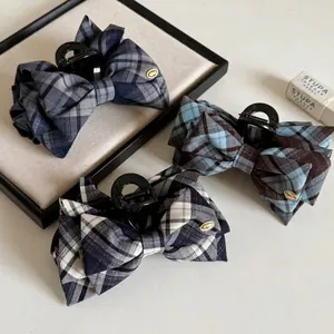 Classic navy plaid bow hair claw clip with golden metal emblem for elegant styling