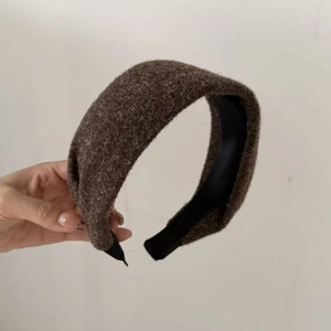 Détail du serre-tête épais marron en peluche montrant le tissu doux et la doublure noire