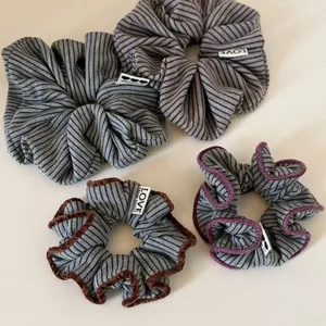 Detail of striped knitted scrunchies with plush velvet edges and LOVE decorative labels