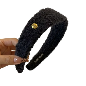 Serre-tête en laine d'agneau noire avec bouton doré et design large à dessus haut