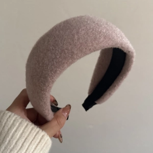 Detail of plush pink lamb wool texture and non-slip black inner lining on thick headband
