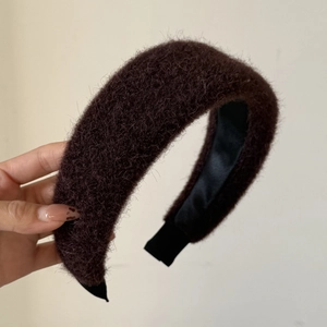 Detailed view of deep brown plush headband with high top design and satin lining