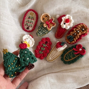 Detail of handmade crochet Christmas hair clips featuring festive tree and Santa designs