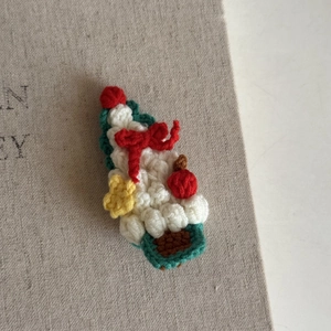 Detailed macro view of handmade crochet Christmas tree hair clip with festive textures