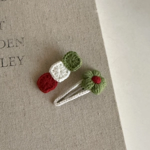 Close-up of handmade crochet Christmas hair clips with knit ball and flower details