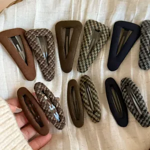Close-up of Fair Isle plaid fabric BB hair clips in classic houndstooth and solid navy colors