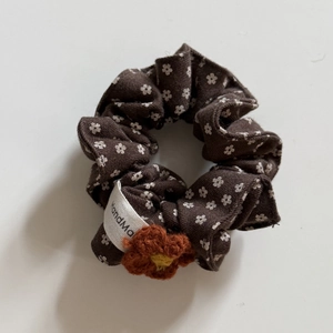 Dettaglio di elastico floreale marrone con fiore intrecciato e trama in cotone