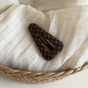 Close-up of vintage brown houndstooth pattern fabric on a triangular metal BB hair clip