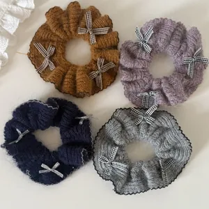 Vue à plat de quatre chouchous en tricot avec des nœuds à carreaux pour le style hivernal