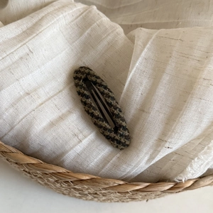 Detailed close-up of brown checkered plaid BB hair clip on a soft textured background