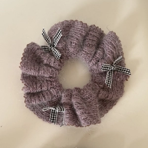 Détail du chouchou en tricot lilas avec des nœuds à motif pied-de-poule pour femmes