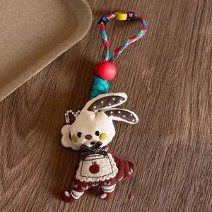 Detailed macro view of handmade bunny pendant with lace textures and colorful beads