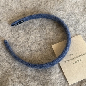 Chic blue knitted mohair headband with a handmade label on soft wool background