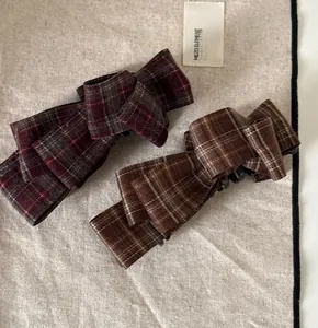 Close-up of checkered banana clips in red and brown fabric for high ponytail hairstyles