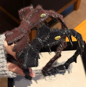 Détail de barrettes nœuds en tricot pailleté noir et café avec étiquettes métal Hand Made