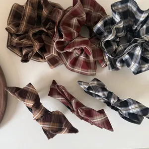 Détail de l'ensemble de chouchous et barrettes à carreaux en marron, rouge et gris