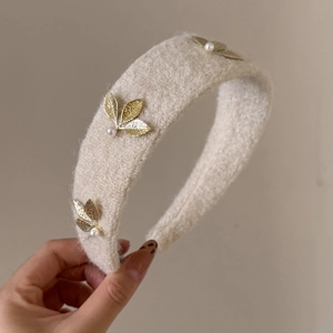 Elegant beige fuzzy wool headband with golden leaf accents and pearls for women