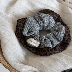 Detail of leopard print fabric and grey crochet wool hair scrunchie with handmade label