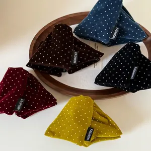 Vintage velvet polka dot hair clips in diverse colors displayed on a wooden tray