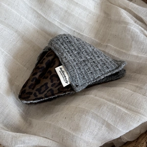 Detail of leopard print stitching on gray waffle fabric hair claw with brand label