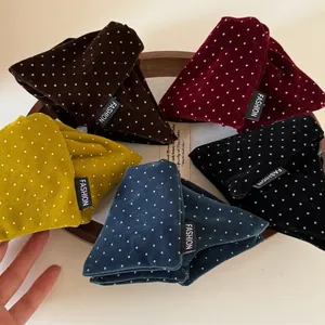 Vintage velvet polka dot hair claws in five colors on a rustic wooden tray