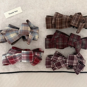 Detailed view of British plaid fabric bow hair clips in five vintage color patterns