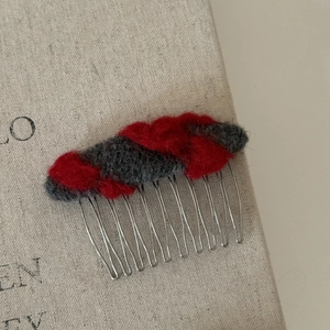Détail d'un peigne à cheveux vintage en feutre avec fil rouge et gris sur métal