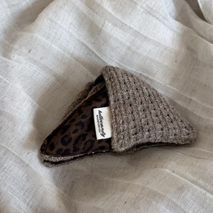 Detailed view of leopard print lining and brown knitted texture on triangular hair clip