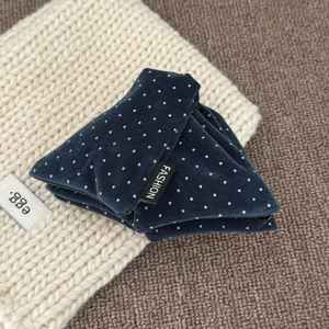 Vintage navy blue polka dot velvet hair claw clip with fashion label on a soft knit fabric
