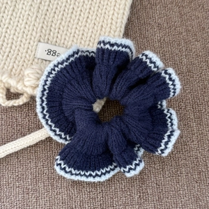 Chouchou en tricot bleu marine avec bordure ondulée blanche pour coiffure de femme