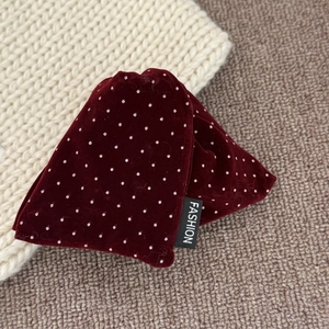 Detail shot of vintage burgundy velvet hair claw clip with pink polka dots and fashion label