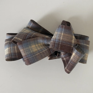 Plaid pattern bow hair clip in brown and blue colors with a vintage aesthetic look