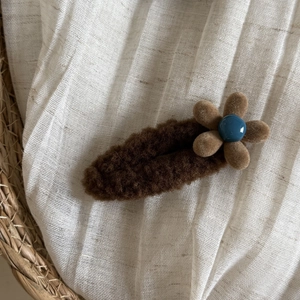 Plush brown flower hair clip for women featuring elegant fleece texture and blue bead accent