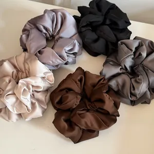 Detailed view of 5-piece set of large satin scrunchies in assorted neutral colors
