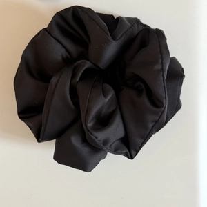 Glossy black satin scrunchie with soft cotton filling for extra volume and hair comfort