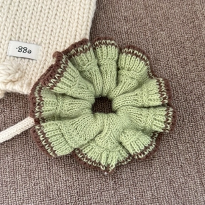 Vue macro d'un chouchou en tricot vert avec bordure marron et texture de pétales