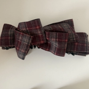 Detail view of red and grey plaid fabric layers on a vintage bow hair banana clip