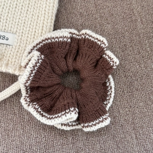 Détail d'un chouchou en maille double couche marron et beige avec bordure ondulée