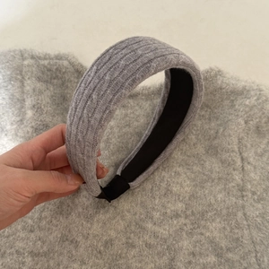 Détail d'un serre-tête tricoté gris avec texture torsadée classique et sensation de laine douce