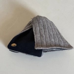 Détail du tricot gris et d'une plaque dorée en métal avec gravure love sur l'article
