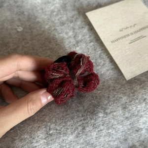 Macro detail of a winter burgundy knit double bow hair claw clip with vintage texture