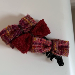 Detailed view of tweed and wool bow banana clip with multi-colored fabric textures